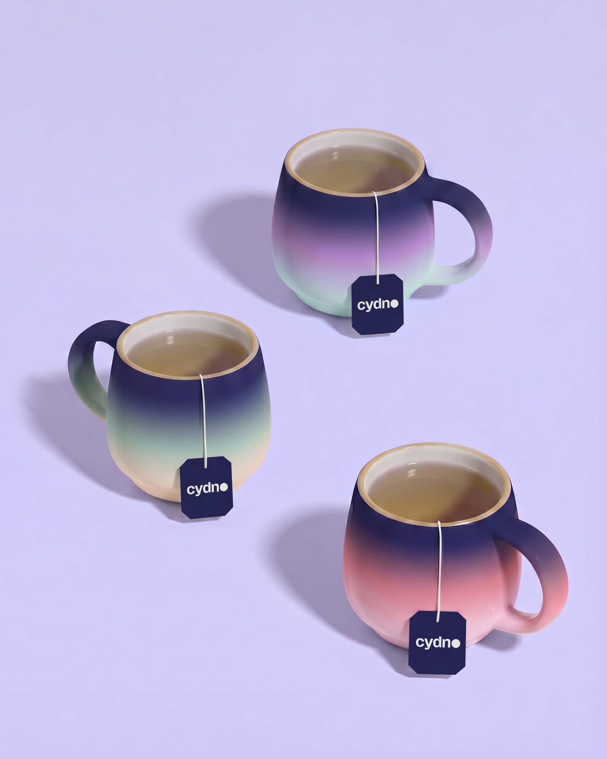 Three ceramic mugs in green, pink and peach gradient glaze with navy Cydno teabag tags